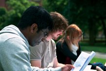 Students studying outside on the grass