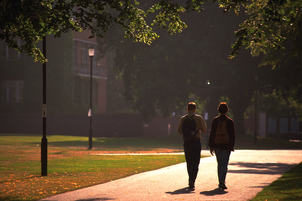 Students walking across campus in the dusk