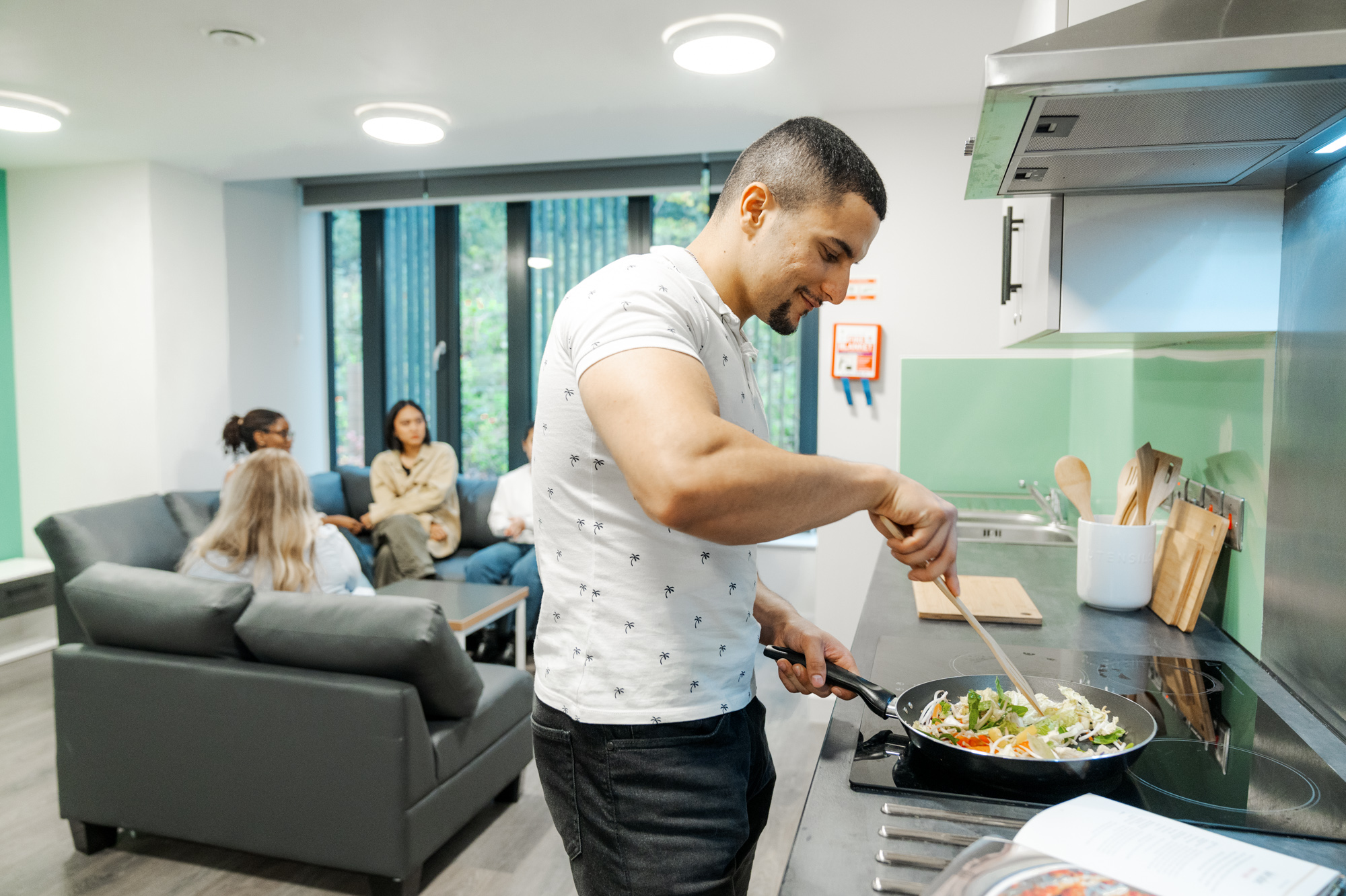 Student cooking a stir fry in their kitchen.