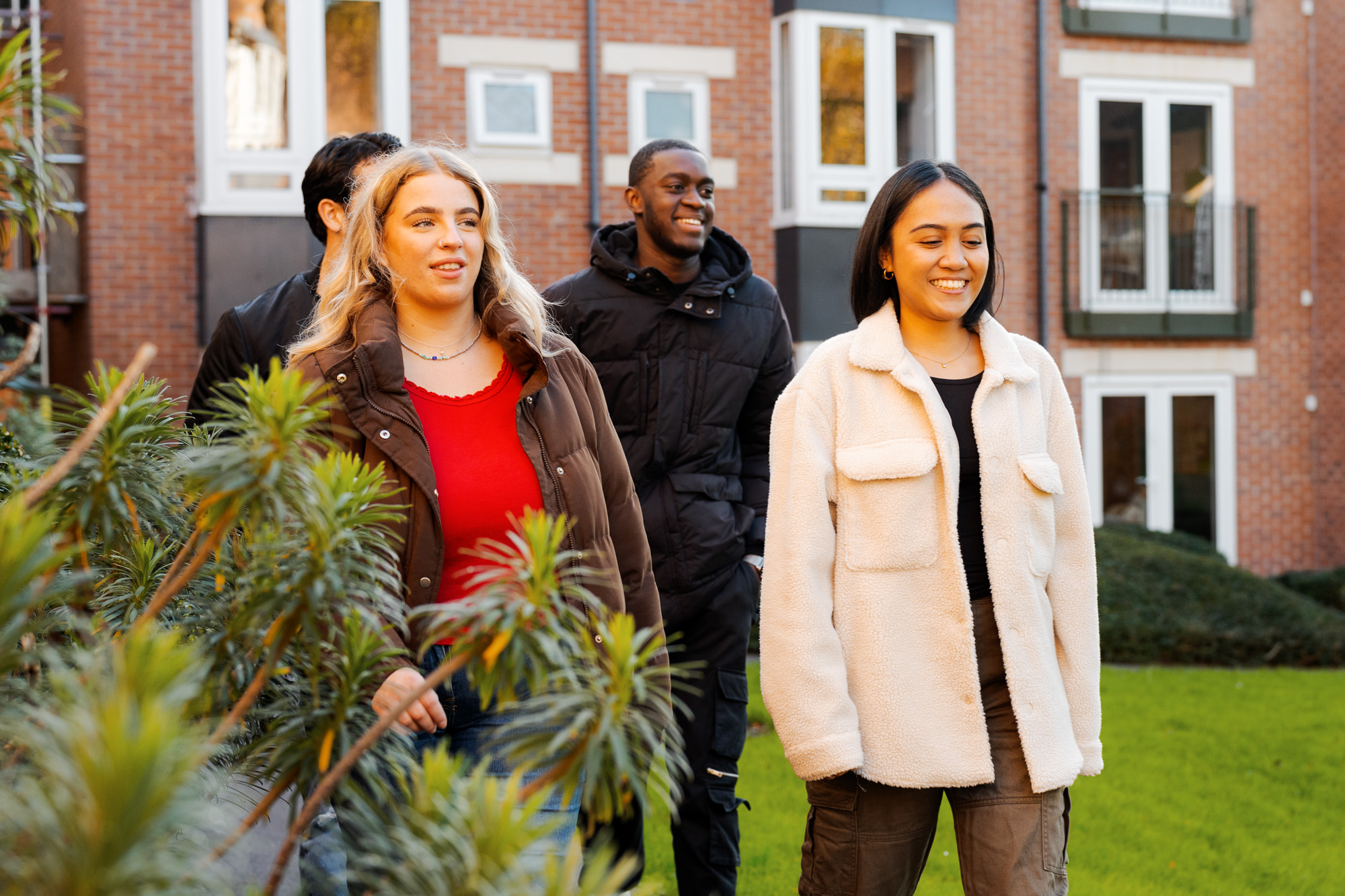 Four students walking outside their accommodation