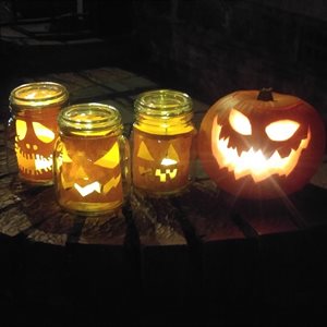 Lanterns made of pumpkins and paper cut to look like scary faces for Halloween