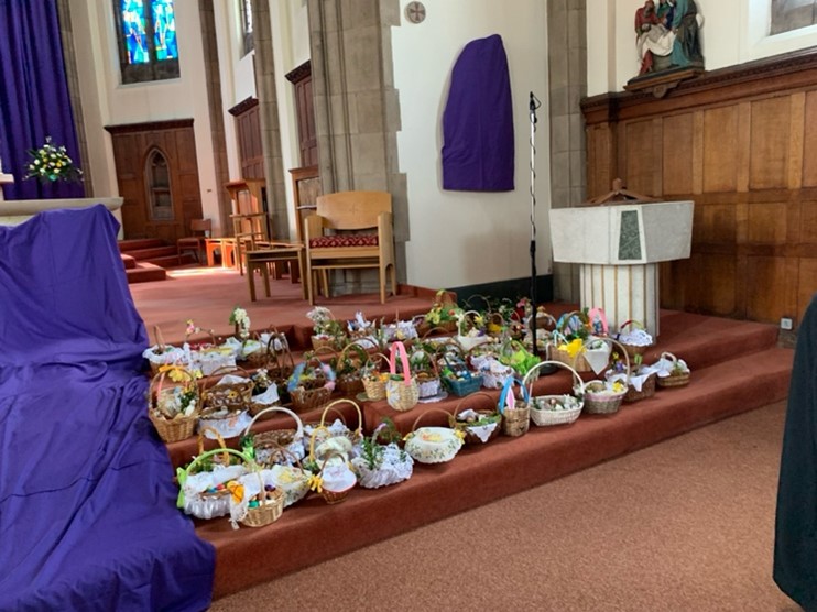 Special Easter baskets lined with linen and decorated with greenery contain symbolic foods such as polish sausage, and have been placed on the steps to the alter inside church