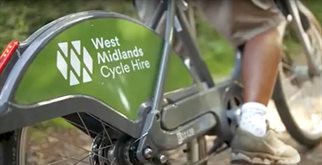 A woman riding a branded bicycle from West Midlands Cycle Hire