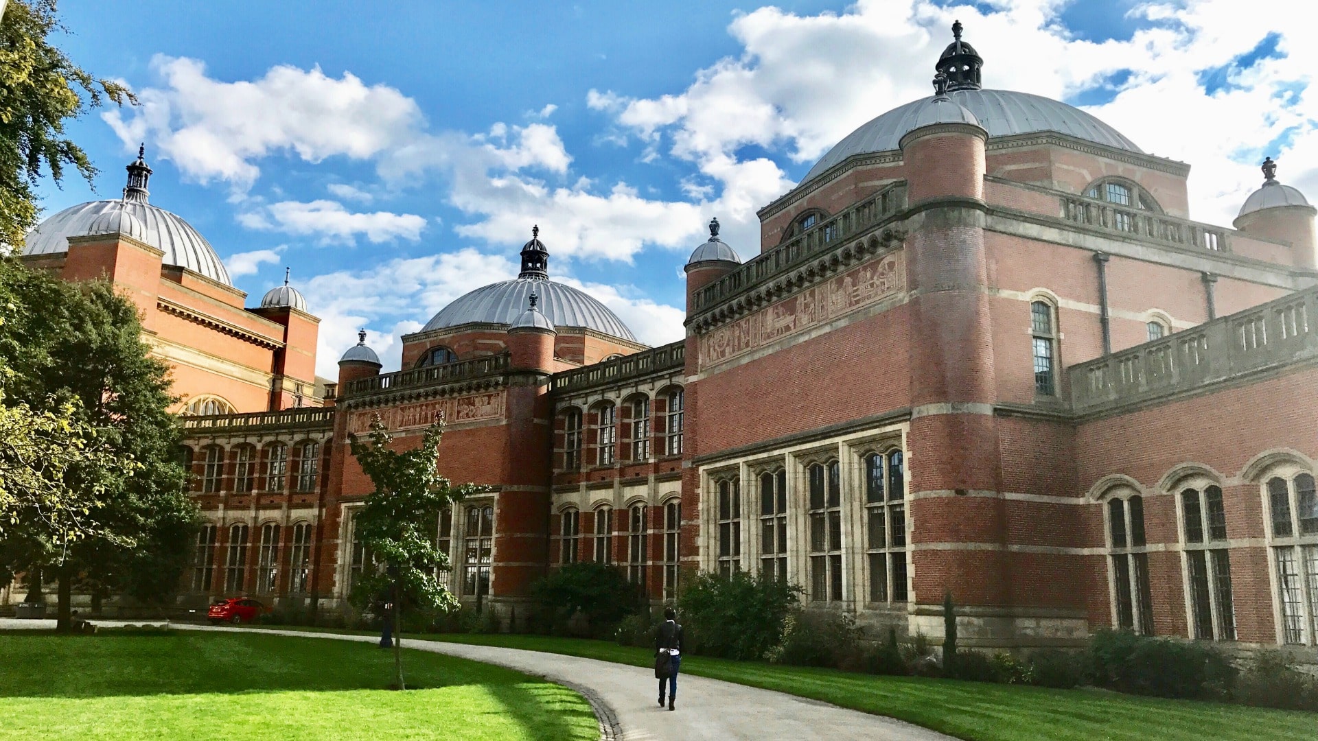 The University of Birmingham's Aston Webb building against a blue sky with white clouds.