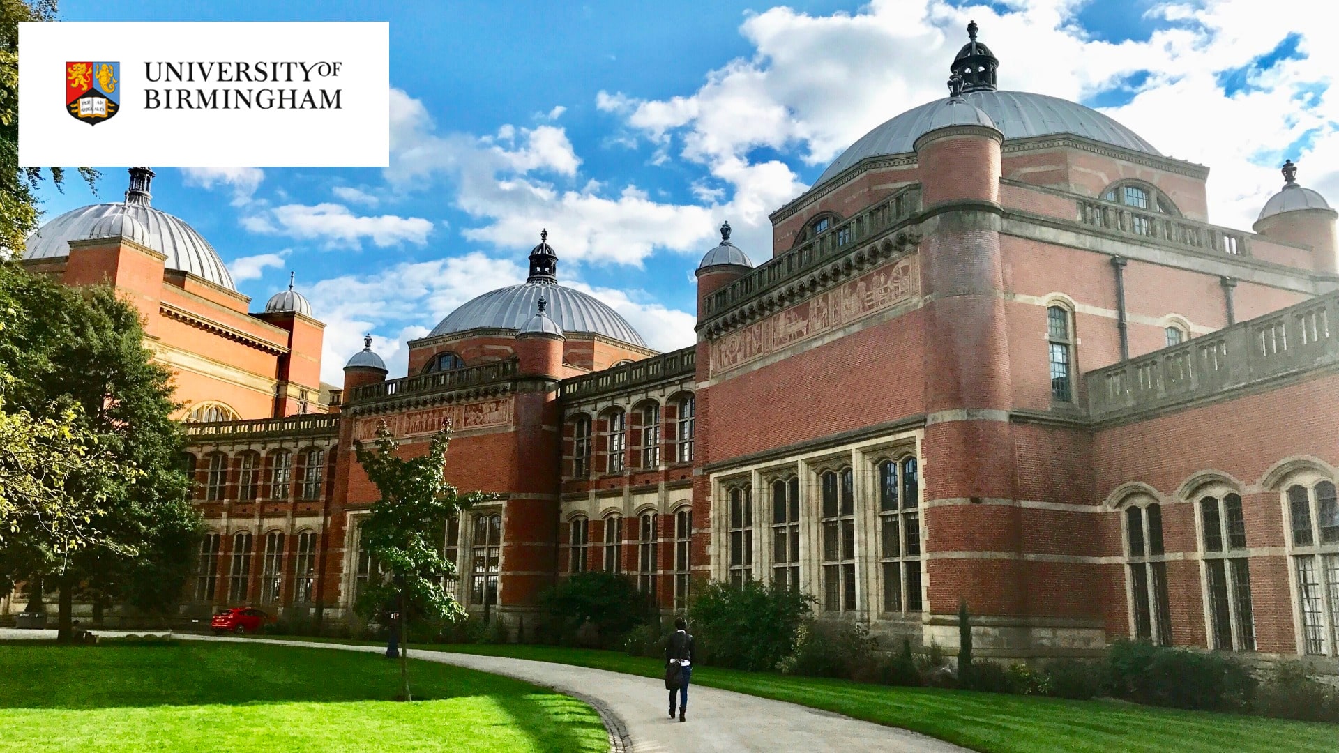 The University of Birmingham's Aston Webb building against a blue sky with white clouds.