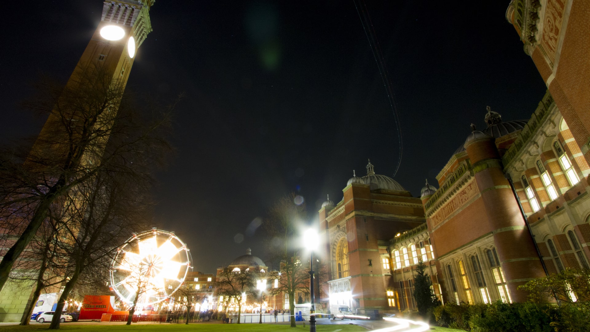 A long exposure of the Christmas fair in Chancellor's Court, with lights from the Ferris Wheel and other attractions lighting up the night.