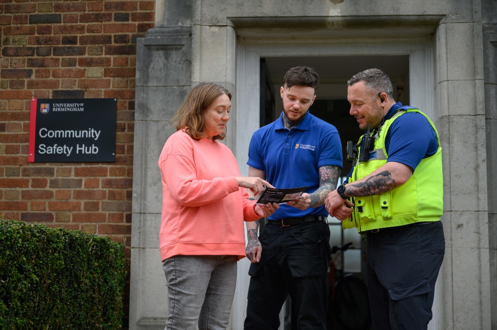 Student talking to members of the Community Safety and Security team outside the Community Safety Hub.