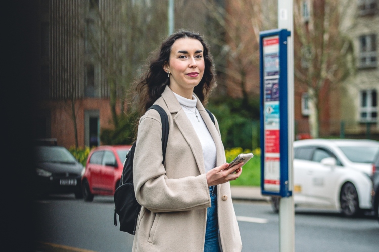 Student waiting at bus stop in Selly Oak