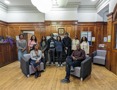 10 Anniversary Scholars smiling in a wood-panelled University room