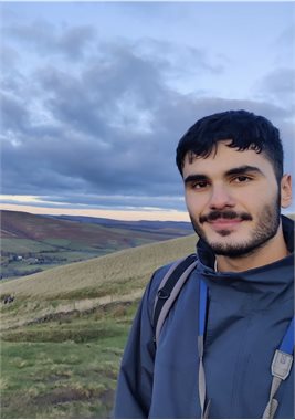 A person in a field smiling at the camera.