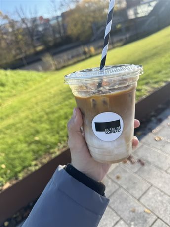 A student holding a cup of coffee