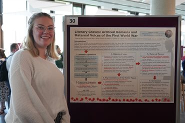 A PGR, Natalia Carter, stands next to her winning poster