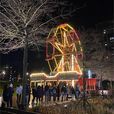 The big wheel on campus is lit up at night.