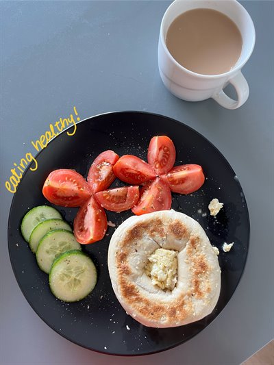 A photo showing a cup of tea with a plate of breakfast. Some yellow text reads 'eating healthily'.