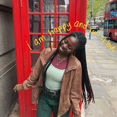 A girl stands in front of a red telephone box smiling. Some yellow text reads 'I am happy and full of love'.