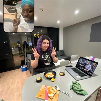 A photo from BeReal showing two girls making peace signs as they eat dinner.