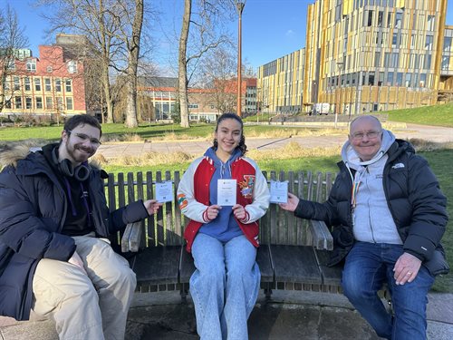 Student Content Shapers Robert, Hanna and Robin sit on a bench with Conversation Starter cards.