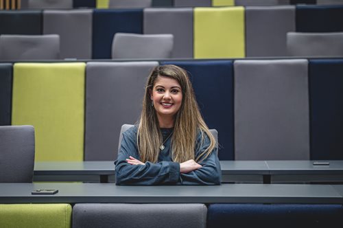 Student Content Shaper Katrina, sitting in a lecture theatre.