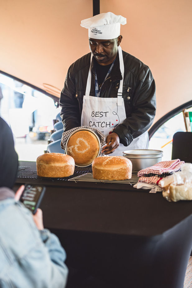 Pastor Obi presents a freshly baked loaf with a heart design.